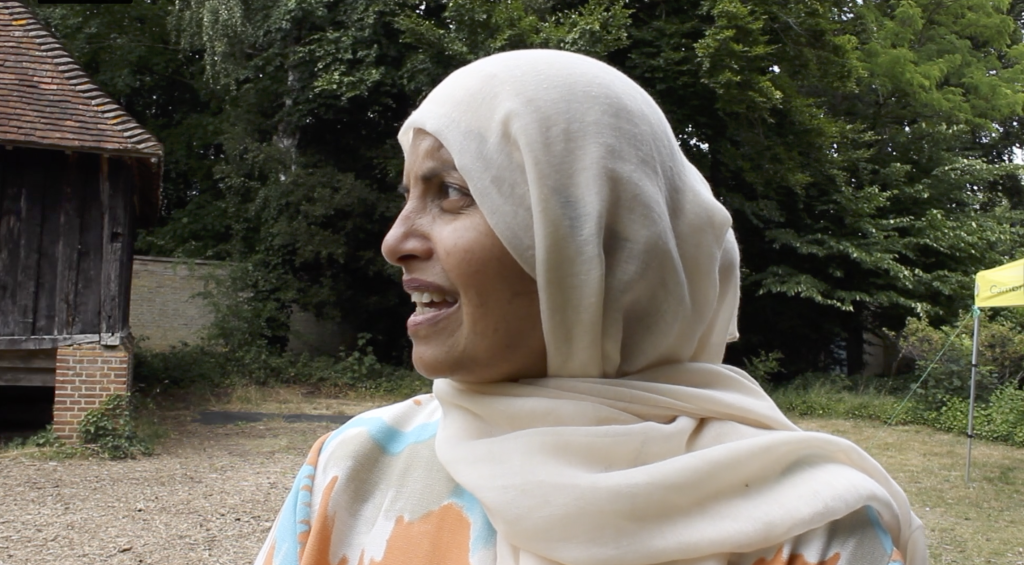 Woman with a head covering, talks, facing to the side